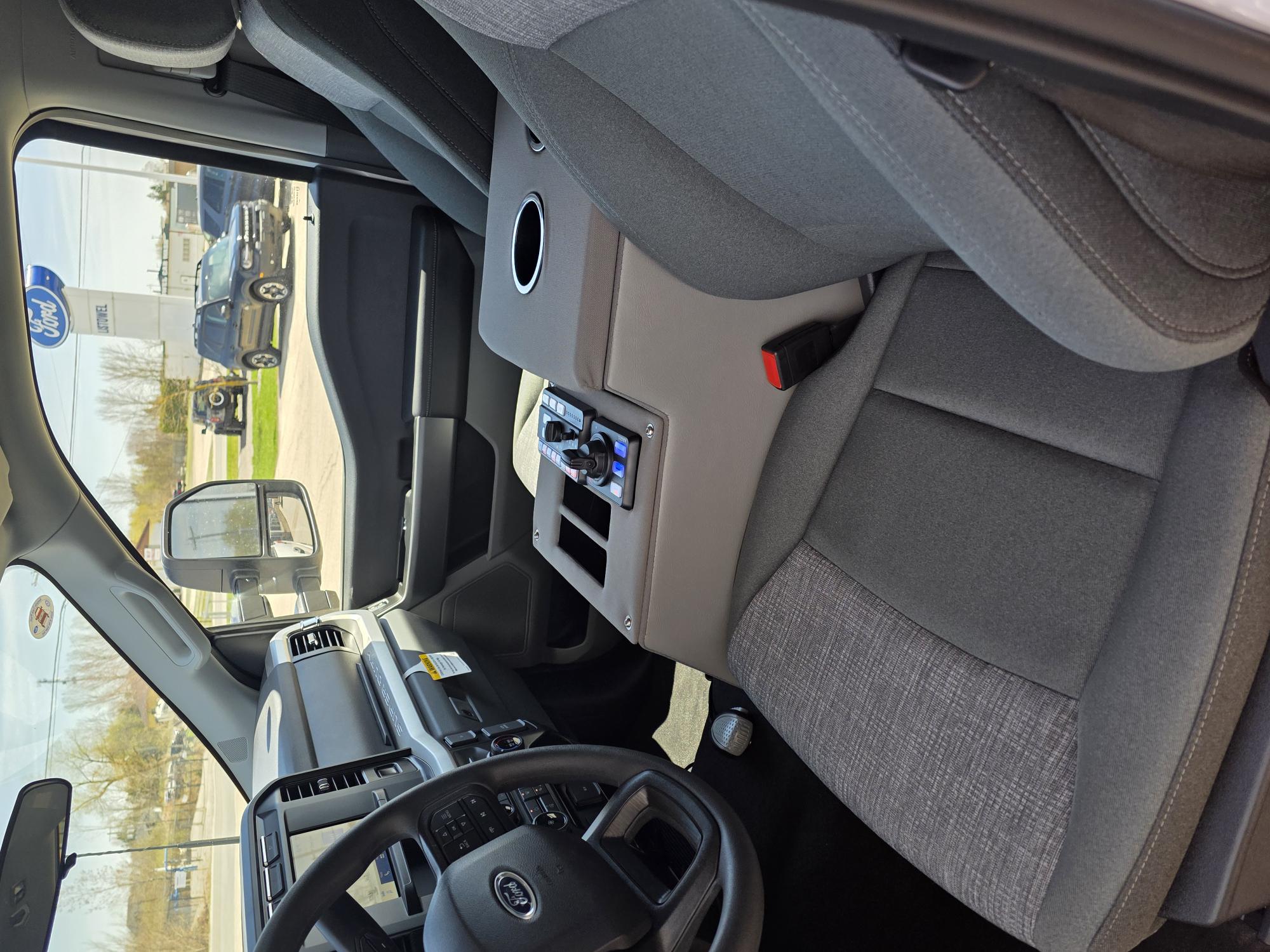 Custom emergency vehicle cab interior with integrated center console and controls